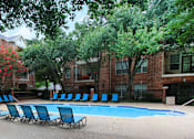 Thumbnail 72 of 73 - A pool surrounded by trees and chairs.