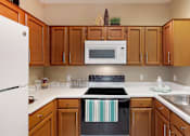 Thumbnail 11 of 73 - U-shaped kitchen with breakfast bar at The Saxony Apartments in north Dallas.