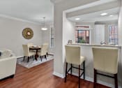 Thumbnail 20 of 26 - Spacious dining room with built-in bookshelves, hardwood floors, breakfast bar, and French doors at Tuscany Villas Apartments in Houston.