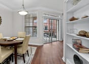 Thumbnail 12 of 26 - Spacious dining room with built-in bookshelves, hardwood floors, and French doors at Tuscany Villas Apartments in Houston.