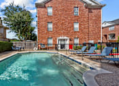 Thumbnail 19 of 34 - Luxury townhomes with swimming pool and poolside lounge seating at Tuscany Row in Houston.
