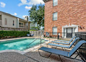 Thumbnail 22 of 34 - Luxury townhomes with swimming pool and poolside lounge seating at Tuscany Row in Houston.