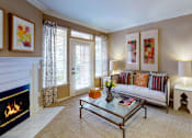 Thumbnail 1 of 36 - Spacious living room with wood-burning fireplace, French door, crown molding, 9-foot ceilings, full-size washer and dryer, at Tuscany Apartments in Houston.