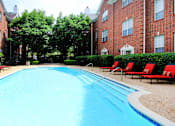 Thumbnail 2 of 26 - Luxury swimming pool with spacious sundeck, beautiful landscaping, and pool-side lounge seating at Tuscany Villas in Houston.