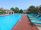 Thumbnail 27 of 30 - Huge swimming pool with spacious sundeck, poolside lounge chairs, beautiful landscaping, and scenic views at The Vanderbilt Apartments in Omaha, Nebraska
