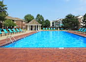 Thumbnail 11 of 30 - Huge swimming pool with spacious sundeck, poolside lounge chairs, beautiful landscaping, and scenic views at The Vanderbilt Apartments in Omaha, Nebraska