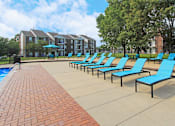 Thumbnail 18 of 30 - Spacious sundeck with lounge chairs, tables, and umbrellas at The Vanderbilt Apartments in Omaha Nebraska