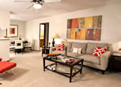 Thumbnail 17 of 30 - A living room with a red chair and a grey couch.