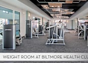 Thumbnail 23 of 36 - A gym with a variety of equipment including weight machines and free weights.