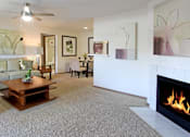 Thumbnail 17 of 44 - Spacious living room with woodburning fireplace and dining room area at Tanglewood Apartments in Lincoln Nebraska