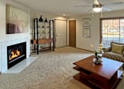 Thumbnail 37 of 44 - Spacious living room with woodburning fireplace, large patio door windows and patio at Tanglewood Apartments in Lincoln Nebraska