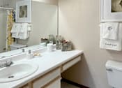 Thumbnail 33 of 44 - Bathroom with tiled floor, tiled shower with bathtub, cabinet space and built-in vanity at Tanglewood Apartments in Lincoln Nebraska