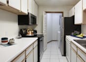 Thumbnail 9 of 44 - Spacious kitchen with lots of cabinet space, lots of counter space, tiled floors, bright white kitchen, full-sized washer and dryer in separate laundry room at Tanglewood Apartments in Lincoln Nebraska