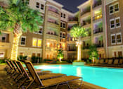 Thumbnail 36 of 36 - Luxury apartments with resort-style pool, palm trees, spacious sundeck with poolside lounge chairs, grilling station, fountains, and fitness center at Villa Piana Apartments in Dallas
