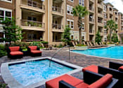 Thumbnail 17 of 36 - Luxury apartments with resort-style pool, spa, palm trees, spacious sundeck with poolside lounge chairs, grilling station, and fountains at Villa Piana Apartments in Dallas