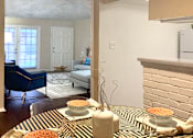 Thumbnail 8 of 22 - Spacious one and two bedroom floor plans with white brick accent walls and wood plank floors at Waters of Winrock Apartments in Houston.