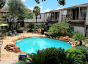 Thumbnail 1 of 22 - Gated apartment community with pool, spa, poolside lounge chairs, lush landscaping, beautiful landscaping, and neighborhood setting in Houston, Texas