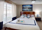 Thumbnail 7 of 22 - A bedroom with a large bed, a ceiling fan, and a painting on the wall.