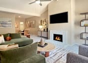 Thumbnail 8 of 38 - A living room with a green couch and a fireplace.