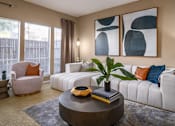 Thumbnail 22 of 38 - Spacious living room with oversized windows, lots of natural light, and woodburning fireplace at Woodlake Oaks Apartments in Houston