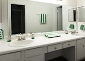 Thumbnail 42 of 42 - Spacious bright white bathroom with extra cabinet and storage space and built-in vanity at Woodlake on the Bayou Apartments in Houston.