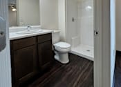 Thumbnail 8 of 14 - A bathroom with a toilet, sink, and mirror.