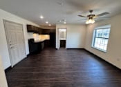 Thumbnail 3 of 14 - A spacious room with a kitchen area and a window.