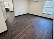 Thumbnail 5 of 14 - A room with wooden flooring and a window with blinds.