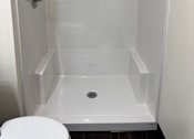 Thumbnail 9 of 14 - A white shower stall with a door and a shower head.