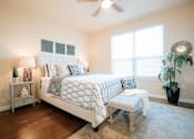 Thumbnail 9 of 11 - A bedroom with a large bed and a bench in front of it.