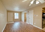Thumbnail 2 of 8 - A room with wooden floors and a ceiling fan.