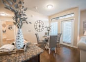 Thumbnail 10 of 11 - A dining room with a table set for four.