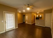 Thumbnail 11 of 14 - A room with a ceiling fan and wooden floors.