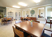 Thumbnail 2 of 11 - A dining room with a wooden table and chairs.