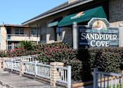 Thumbnail 2 of 3 - Sandpiper Cove is a residential building with a green awning.