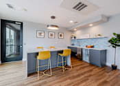Thumbnail 7 of 32 - A kitchen with a bar area featuring yellow stools.
