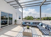 Thumbnail 4 of 32 - A patio with a white pergola and blue cushioned seating.