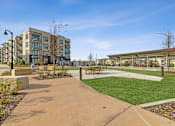Thumbnail 22 of 27 - Apartment community exterior with manicured lawn and multi-story building