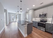 Thumbnail 28 of 32 - A modern kitchen with a large island and stainless steel appliances.
