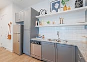 Thumbnail 26 of 32 - A kitchen with a refrigerator, dishwasher, and a sink.