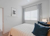 Thumbnail 20 of 32 - A bedroom with a bed, pillows, and a picture on the wall.