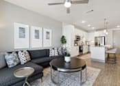 Thumbnail 5 of 27 - Modern living room with sectional sofa, wood-style flooring and city views
