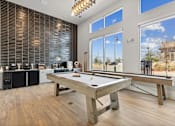 Thumbnail 18 of 27 - A pool table in a room with a kitchen in the background