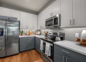 Thumbnail 4 of 26 - a kitchen with gray cabinets and white countertops  at Presidium Revelstoke, Fort Worth, TX, 76131