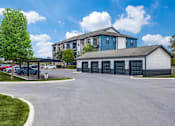 Thumbnail 17 of 17 - A large building with a parking lot in front of it.