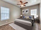 Thumbnail 9 of 17 - a bedroom with a large bed and a ceiling fan  at Valor at Harlingen, Harlingen, Texas
