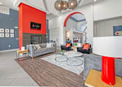 Thumbnail 1 of 13 - a living room with gray couches and a red accent wall  at Collective on Riverside, Austin, TX, 78741