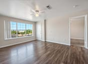 Thumbnail 8 of 13 - an empty living room with a large window and a ceiling fan  at Collective on Riverside, Austin, Texas