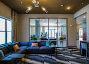 Thumbnail 26 of 27 - A living room with a blue couch and a black and white rug at The Grand at Manor Apartments, Manor