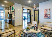 Thumbnail 24 of 27 - A living room with a sofa, armchair, and coffee table at The Grand at Manor Apartments, Texas 78653
